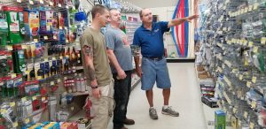 Short and Paulk’s Deker Hixon, right, assists customers Chandler Buchanan and his dad, Don.
